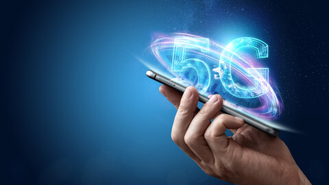 Hand holding cell phone with 5G image above.