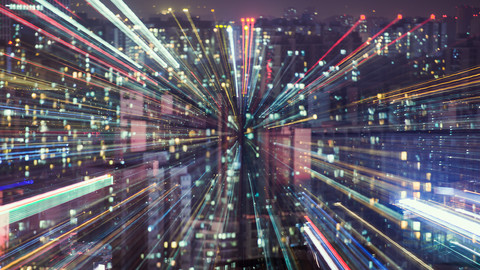 Blurred lines coming to a focal point over an aerial view of a cityscape at night